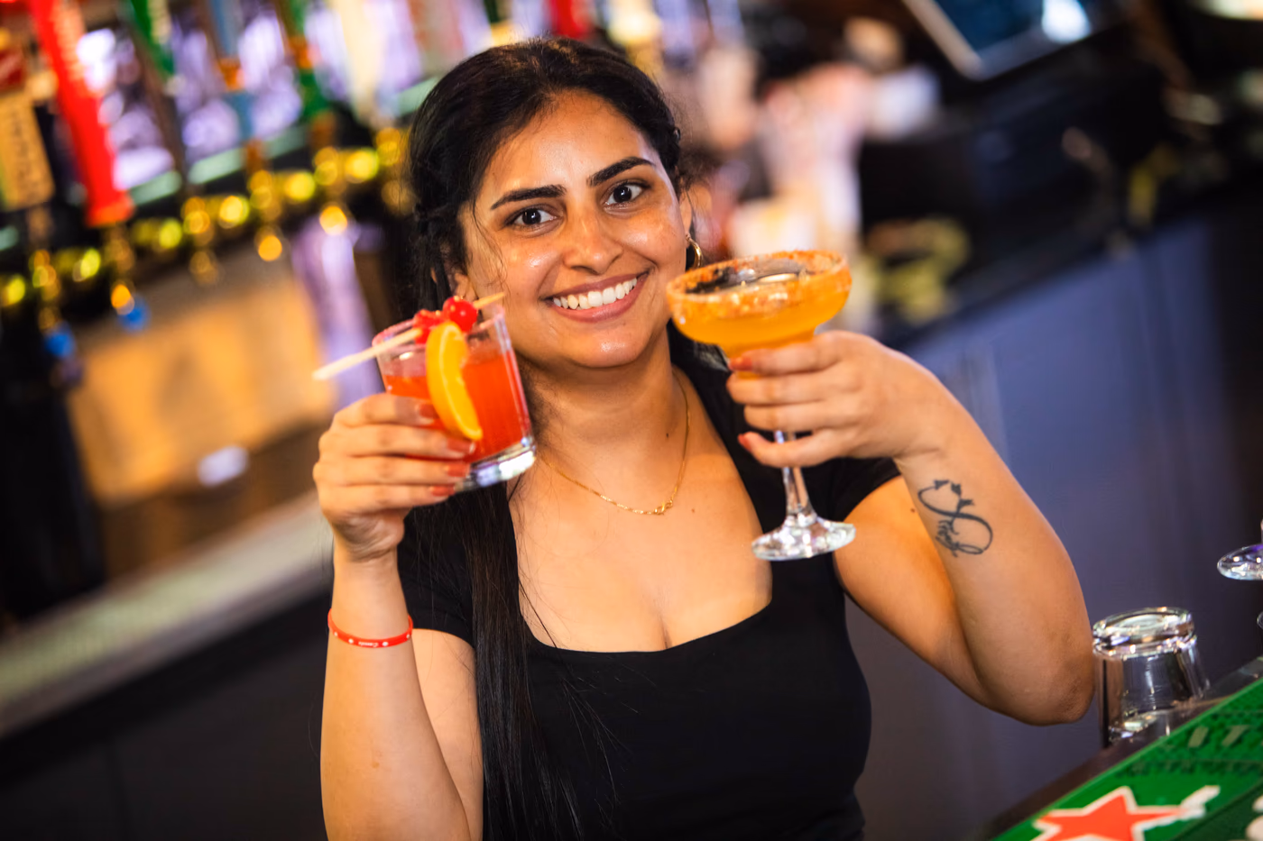 A Pub 36 bartender presenting two freshly made cocktails